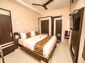 A hotel room with a bed, wardrobe, and a ceiling fan. - OYO 9804 Hotel SR Residency (Vijayawada)