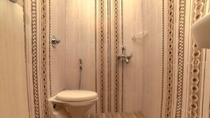 Une salle de bain avec des toilettes, une douche et un lavabo.