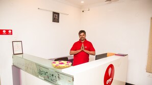 Un comptoir d’accueil avec une cloison en verre, une horloge et un certificat encadré accroché au mur.