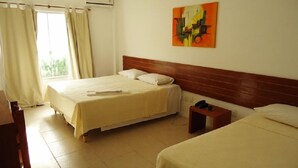 A hotel room with two beds, a wooden headboard, a painting on the wall, and a window with curtains. - Hotel Portal dos Ventos (Parnaíba)