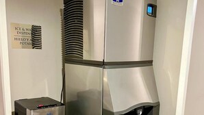 A compact, stainless steel minibar with a water dispenser and a small trash bin. - Hotel Caesar's (Tijuana)