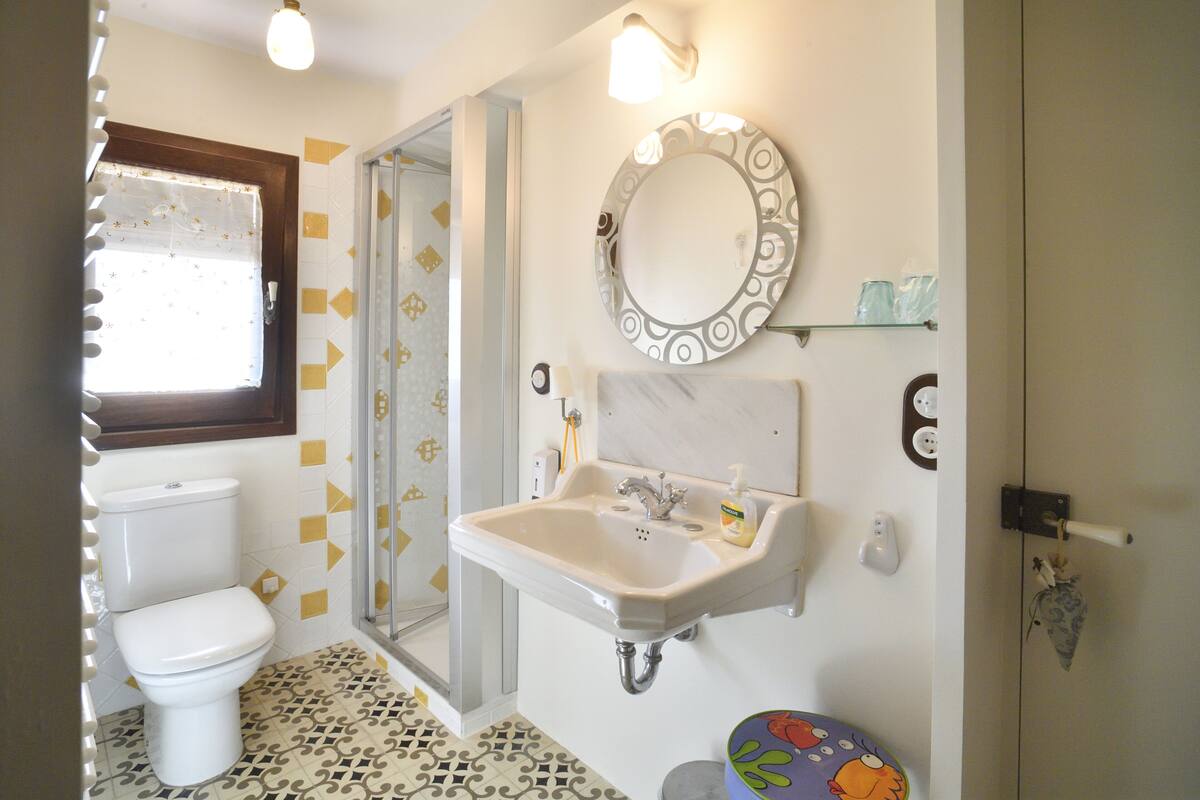 Une salle de bain avec des toilettes, un lavabo et une douche.