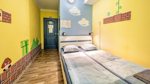 A room with a bed, a door, and walls decorated with pixel art. - Island Hostel - Adults only (Budapest)
