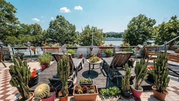 Une terrasse sur le toit, agrémentée de cactus en pot, d’une table et de deux chaises.