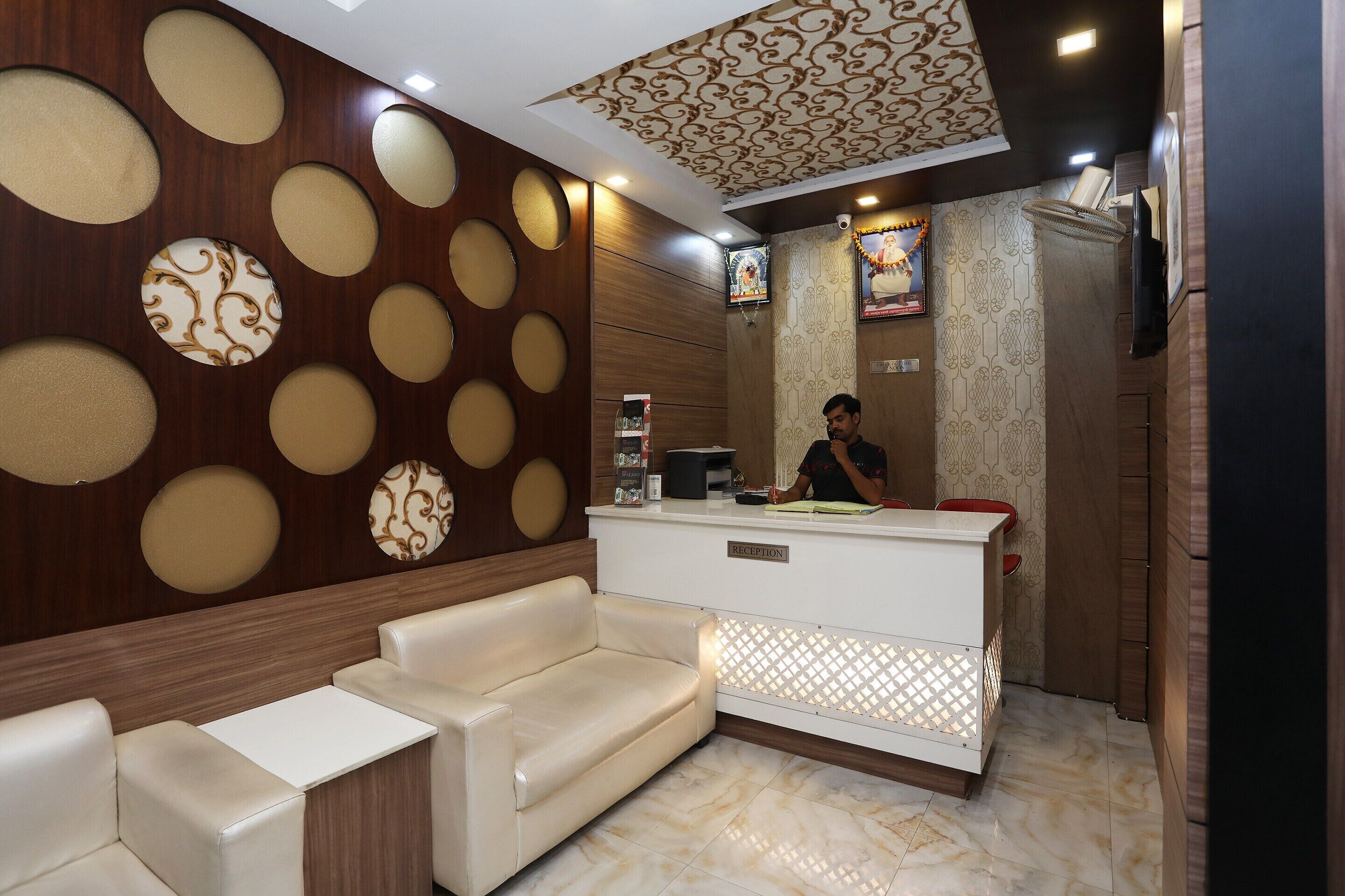 A reception area with a sofa, a reception desk, and a patterned wall.
