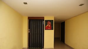 Un passadís amb una porta tancada, un estri i un quadre al mur.