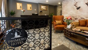 A hotel reception area with a reception desk, a sofa, and a coffee table.