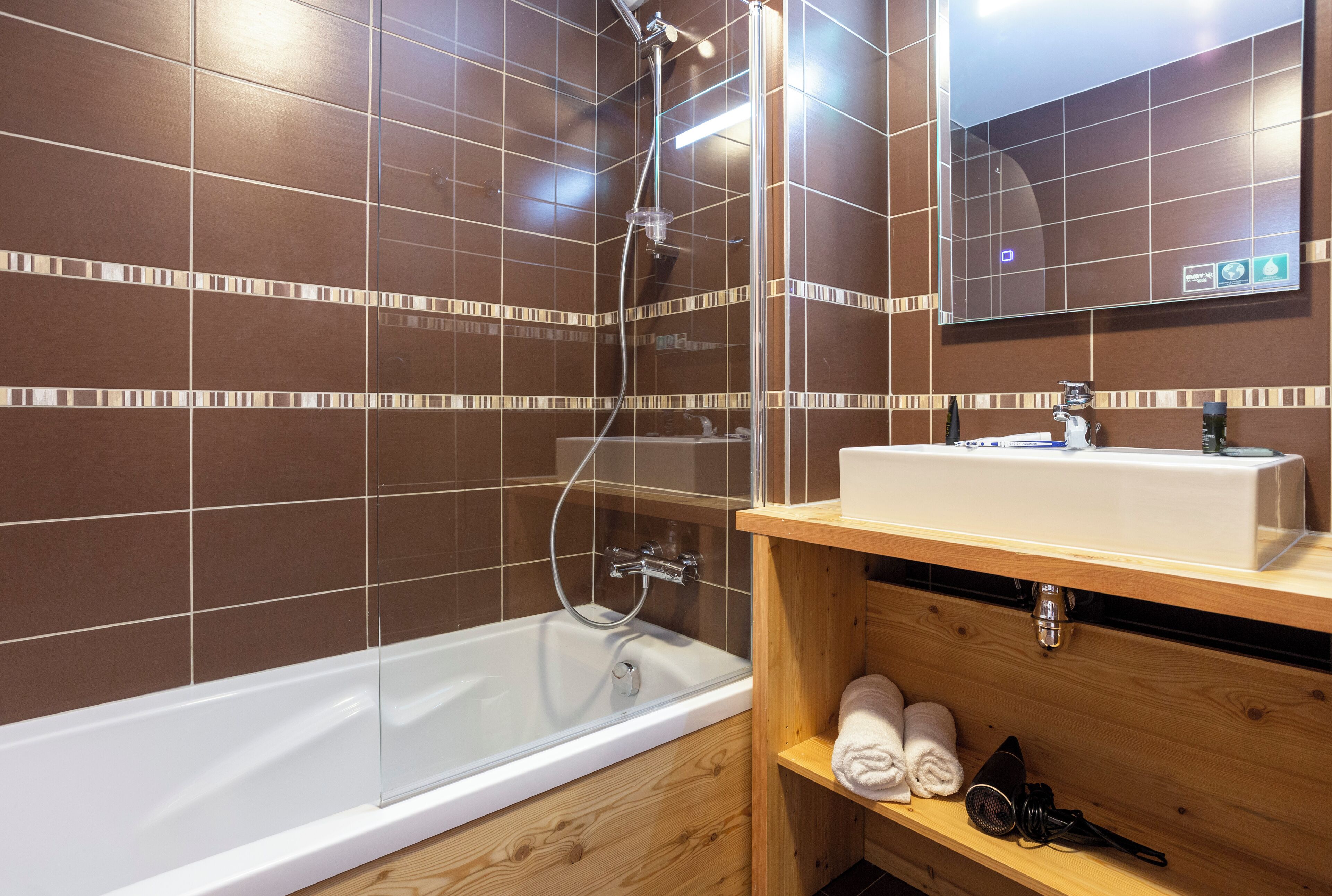 A modern bathroom with a bathtub, a shower, and a vanity with a sink and towel rack.
