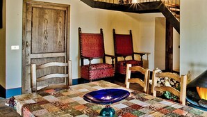 Una cocina rústica con estufa de leña, una mesa de comedor con sillas y armarios de madera.