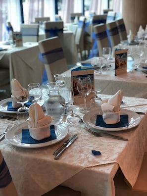 A dining table set with plates, napkins, cutlery, and glasses. - Lido Hotel Residence (Cesenatico)