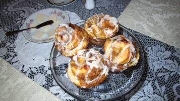A plate of cinnamon rolls on a lace tablecloth.