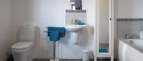Ein Badezimmer mit Toilette, Waschbecken und Badewanne.