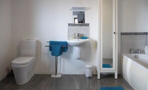 A bathroom with a toilet, sink, and bathtub. - Kinbane Self-Catering (Ballycastle)