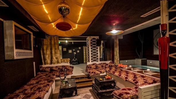 A cozy lounge area with patterned sofas, a coffee table, and a small pool table. - Hotel Friends (Bansko)