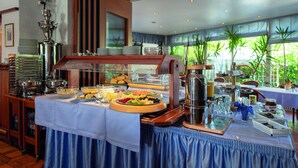Una mesa de buffet con diversos alimentos y una estación de café.