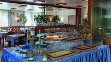 Disposição de buffet com diversos alimentos e utensílios.