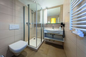 Habitación individual | Baño | Regadera y toallas 