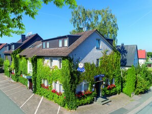Un hotel de estilo arquitectónico europeo tradicional, con tejado a dos aguas y un cartel que indica que es un hotel.