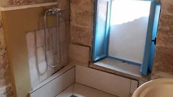 Un baño con ducha, lavamanos e inodoro.