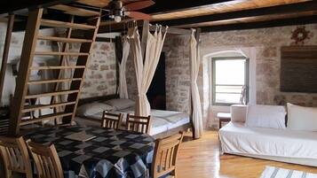 Appartement Deluxe | Coin séjour | Télévision à écran plat, livres