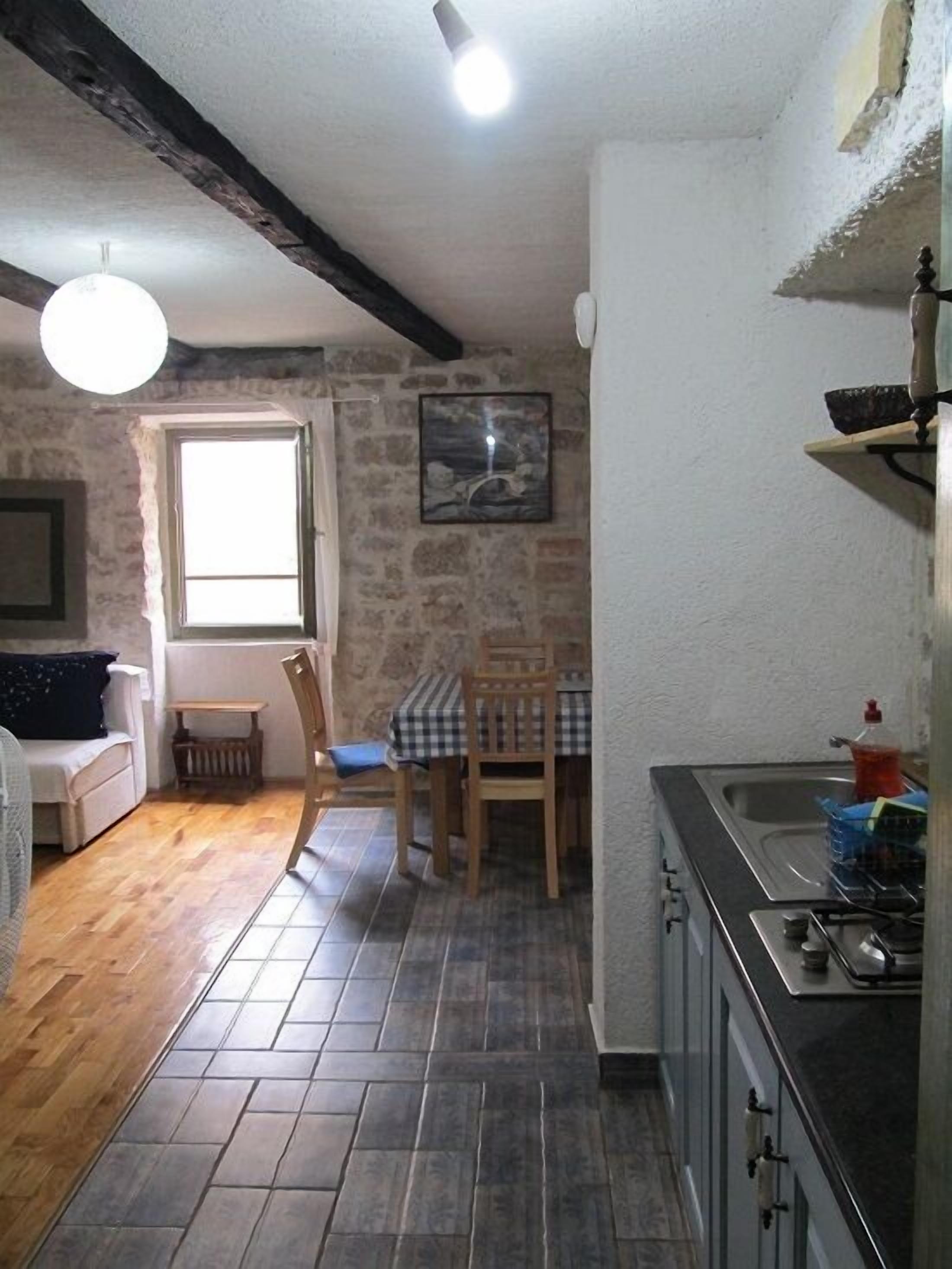 A compact living space with a kitchen, dining area, and a small seating area with a sofa and chairs.