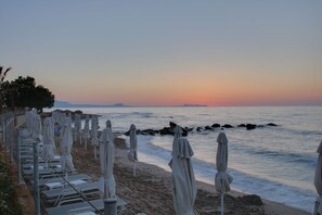 På stranden, solsenger, parasoller og strandhåndklær