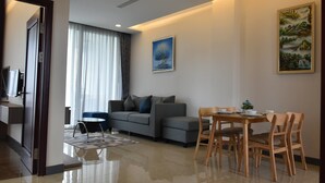 A modern living room with a sofa, a dining table with chairs, and a painting on the wall. - The Park Vientiane (Vientiane)
