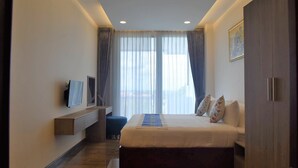 A modern hotel room with a large bed, a flat-screen TV mounted on the wall, and a wooden wardrobe. - The Park Vientiane (Vientiane)