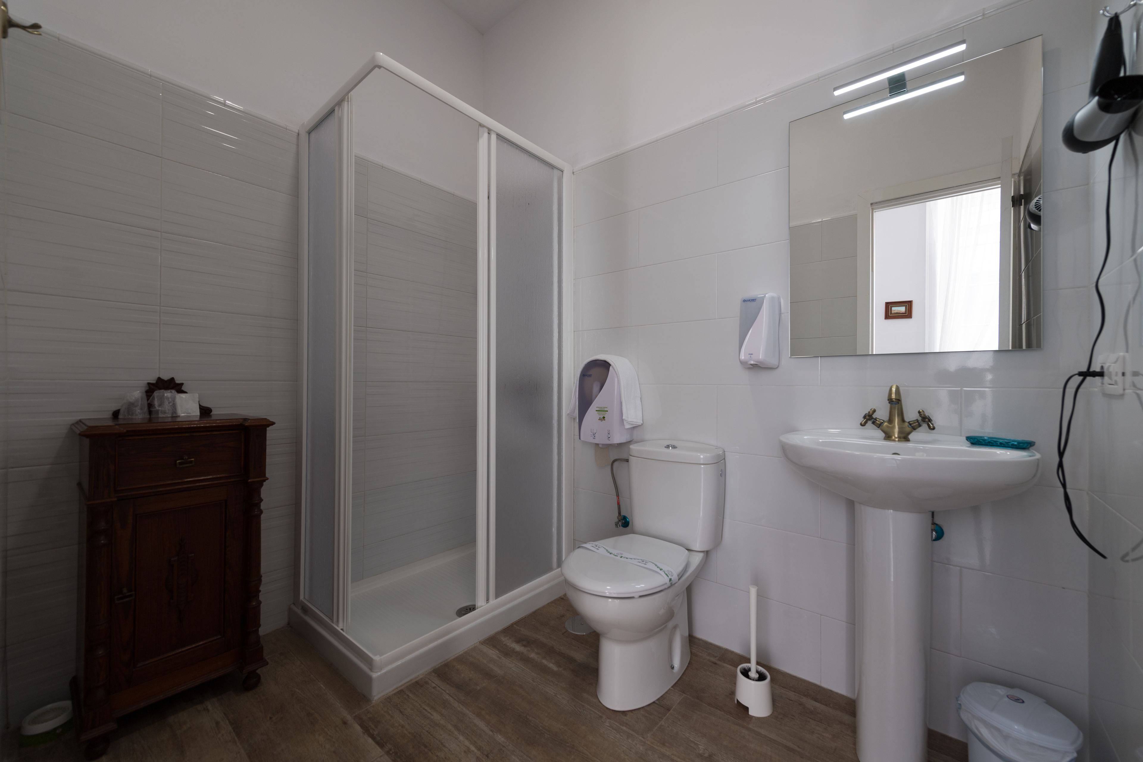 A bathroom with a toilet, sink, and shower.