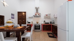 A compact kitchen with a microwave, oven, and a red and white color scheme. - Casa Cinzia (Las Palmas de Gran Canaria)