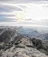 Un paisaje montañoso con terreno rocoso y vegetación escasa.