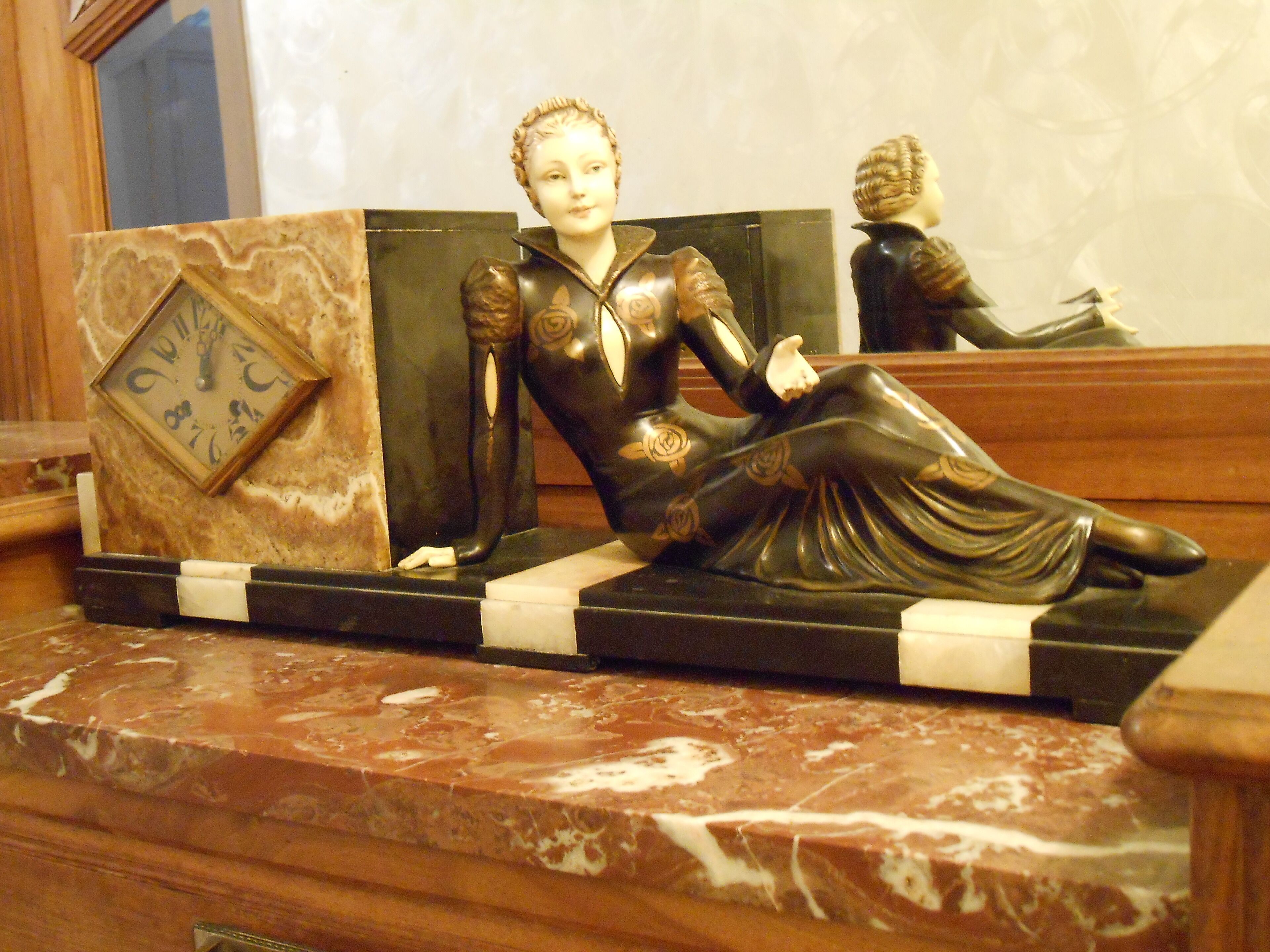 Une statue d’une femme en robe, posée sur une surface en marbre.