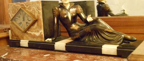 Une statue d’une femme en robe, posée sur une surface en marbre.