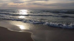 A beach with waves and a sunset.