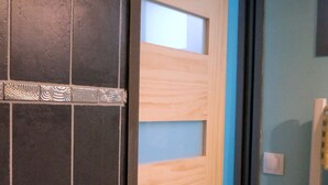 Una puerta de madera con un panel de vidrio satinado y una banda decorativa de metal.