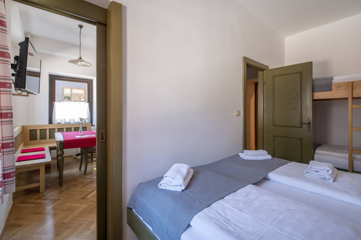 Un dormitorio con cama, escritorio y silla.