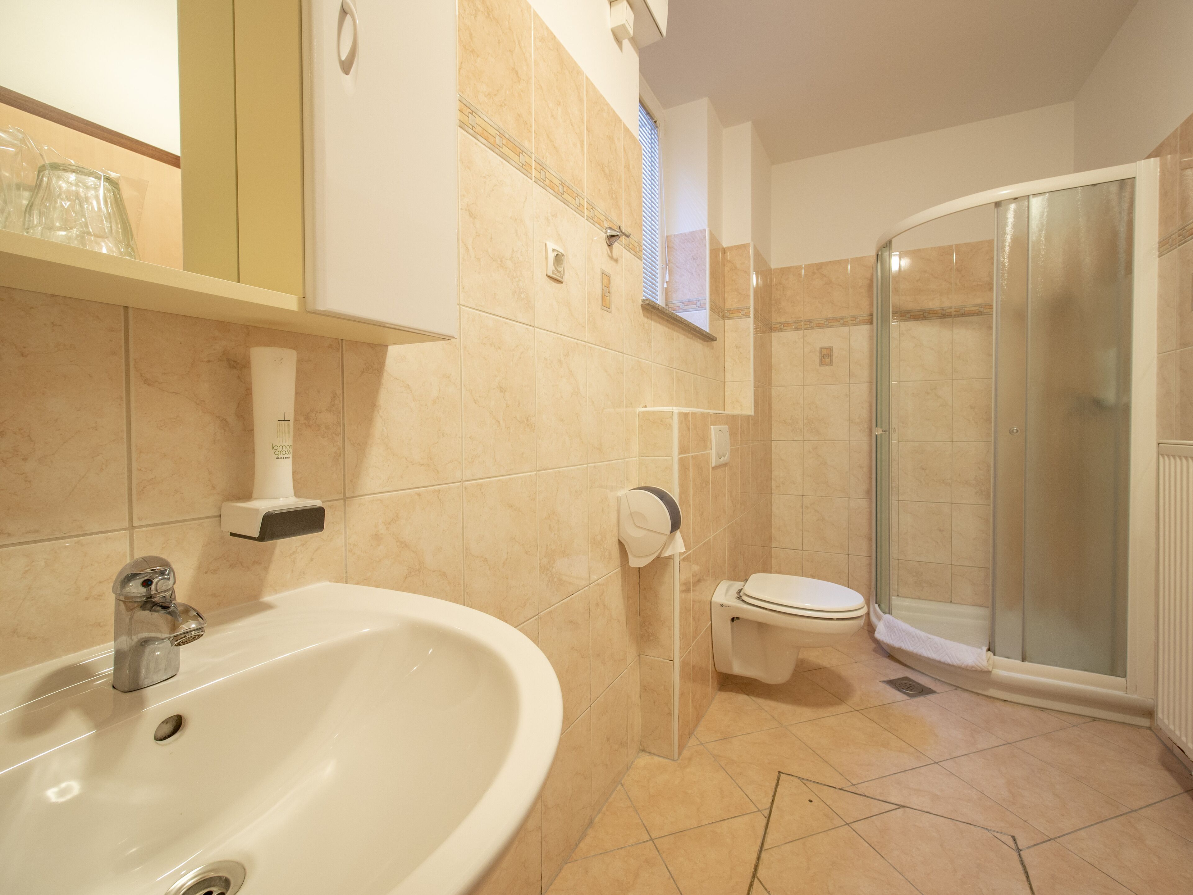 Un baño con lavamanos, inodoro y ducha.