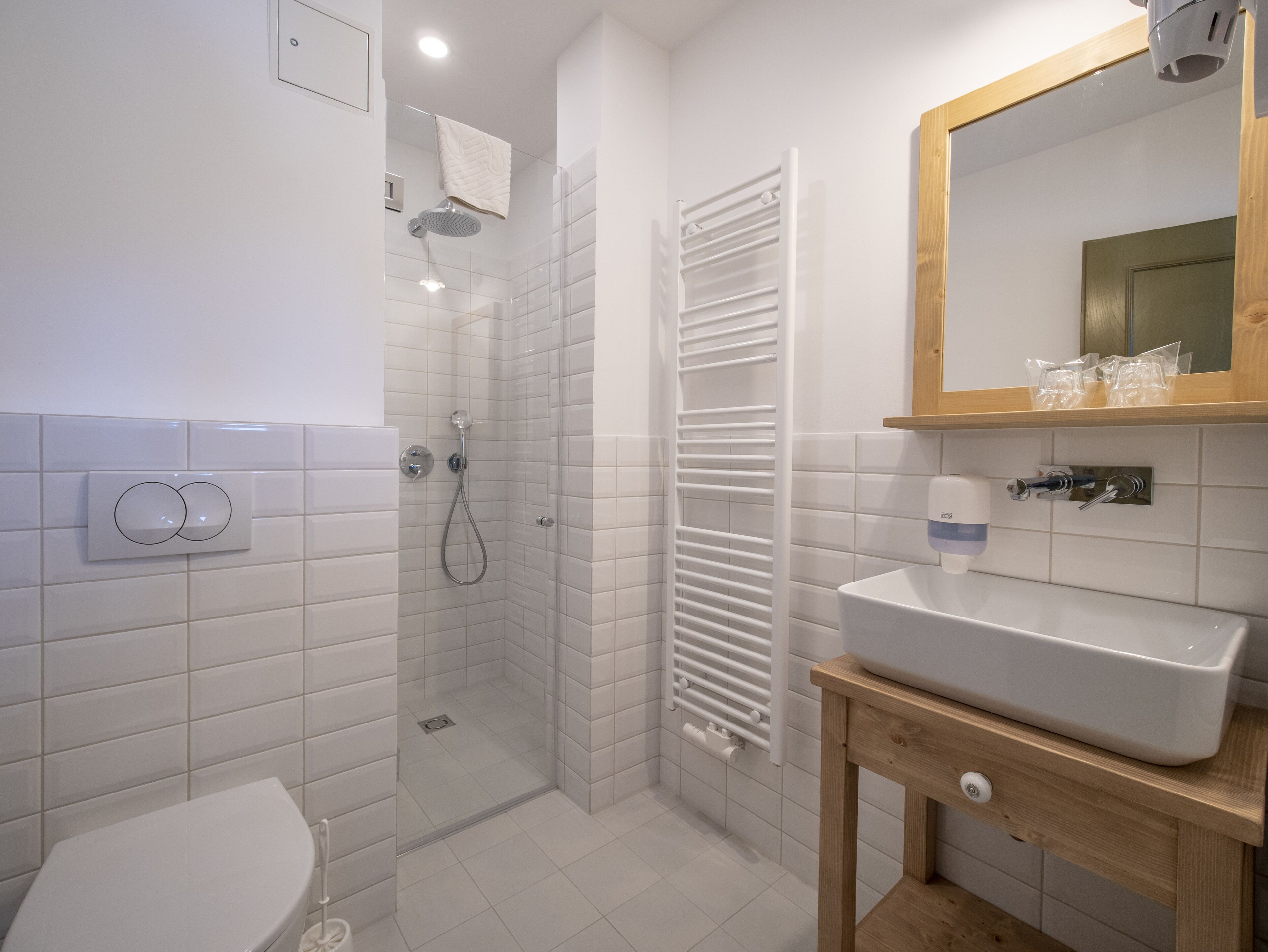 A modern bathroom with a shower, toilet, and sink.