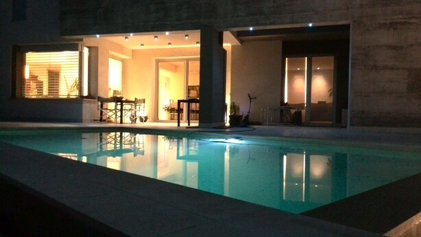 A swimming pool with a modern house in the background.