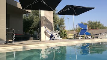 Utomhuspool, infinity-bassäng och solstolar