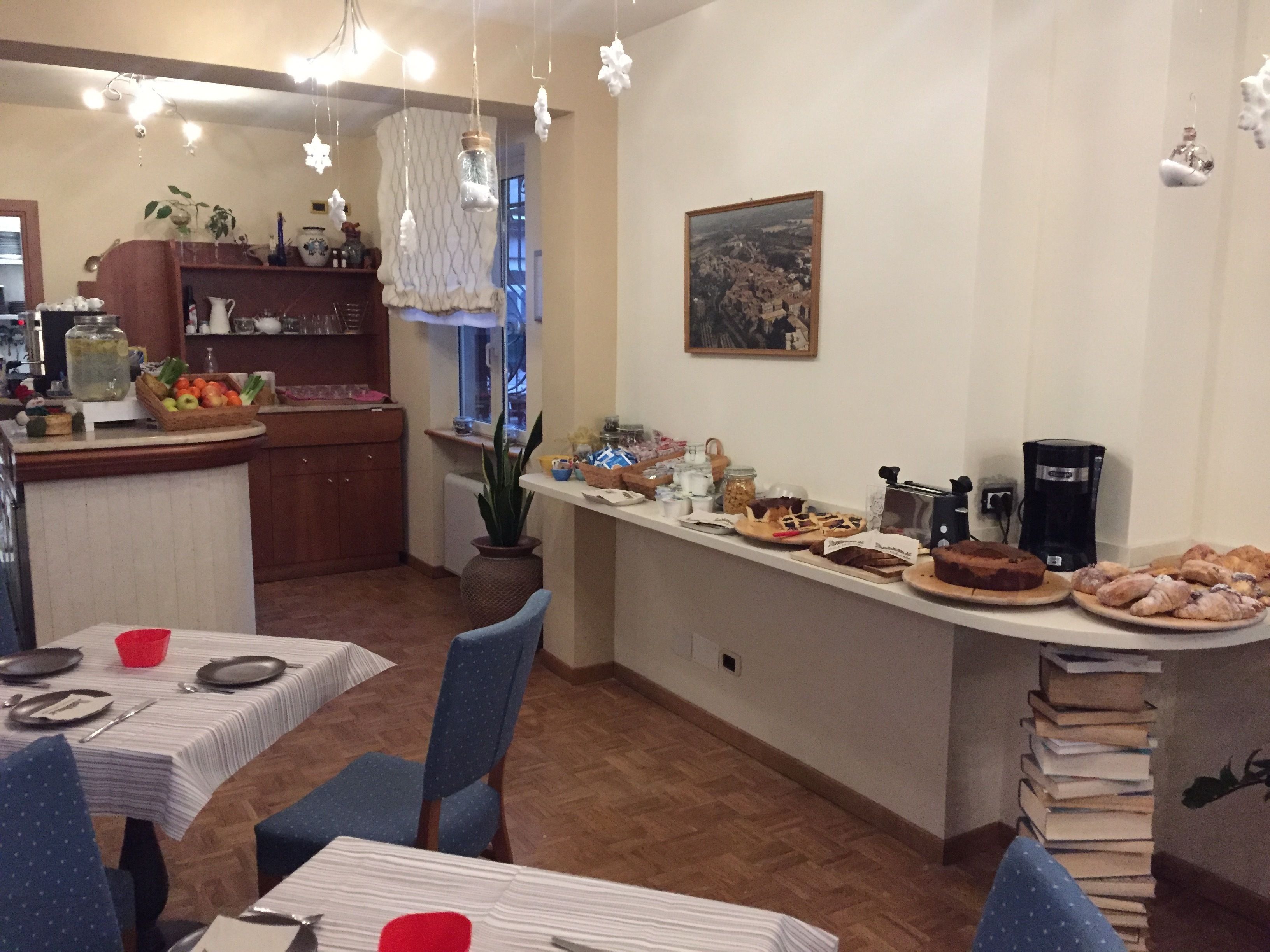 A dining area with a buffet setup, including various food items and a coffee machine.