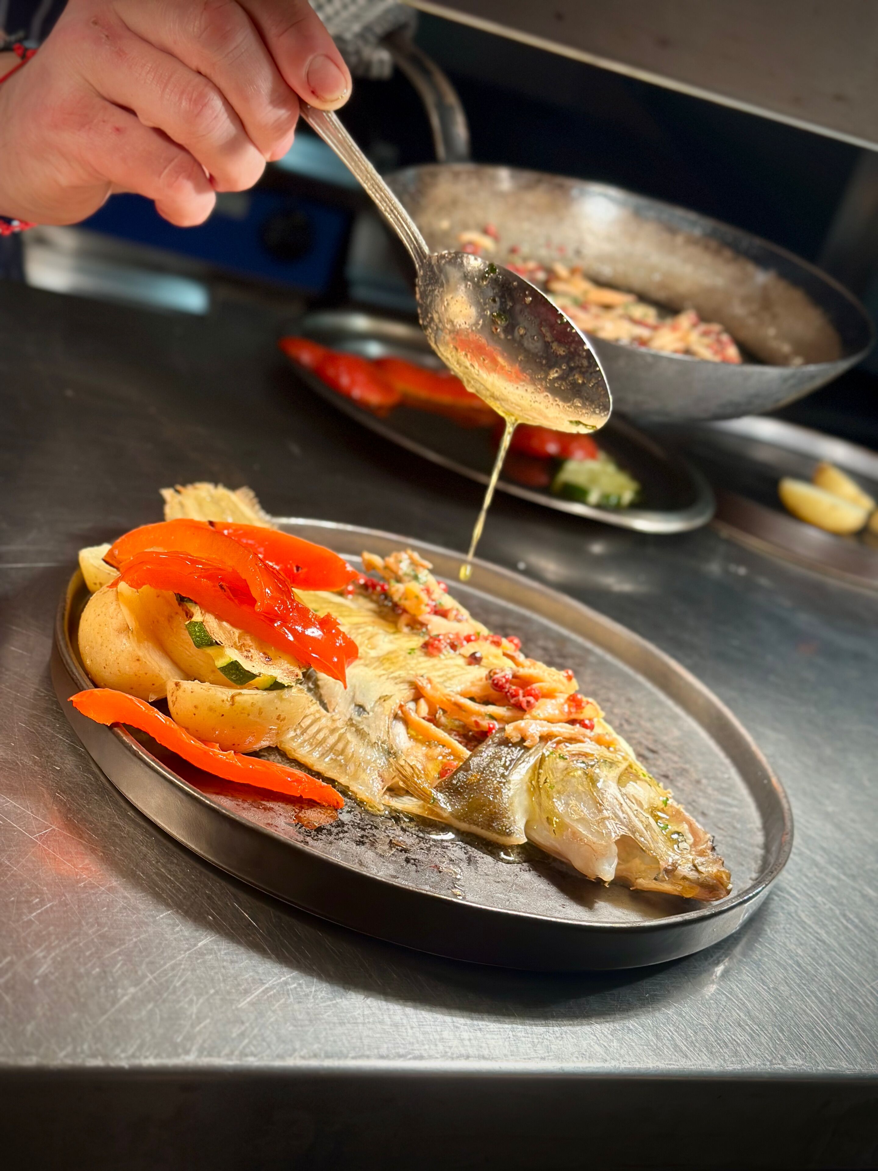 A fish dish with vegetables on a plate.