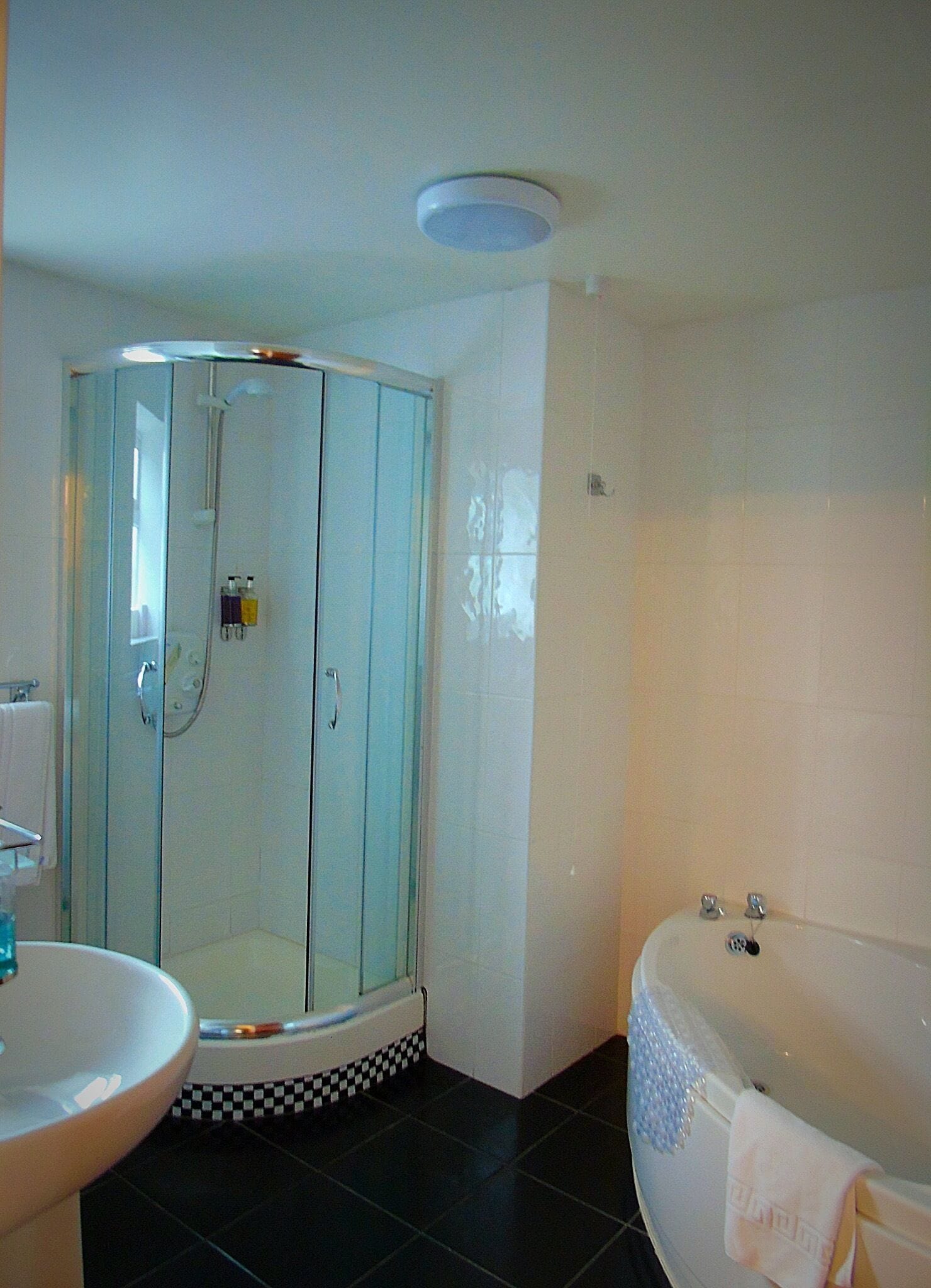 Une salle de bain avec une douche à parois de verre, une baignoire et un lavabo.