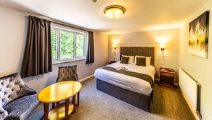 A hotel room with a bed, a small table, a sofa, and a window with curtains. - The Boars Head Hotel (Ashbourne)