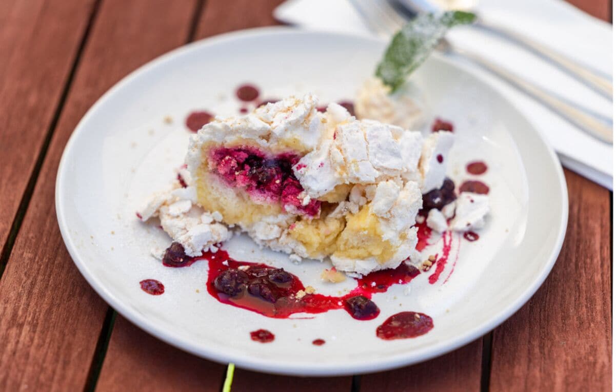 Un postre sobre un plato blanco, con una mesa de madera al fondo.