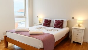 A neatly made bed with a pink blanket, two pillows, and a bedside table with a lamp. - Still Life St. Paul's Executive (London)