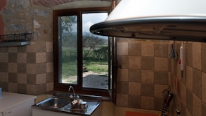 A kitchen with a window, a sink, and a stove. - Agriturismo La Valentina Nuova (Orbetello)