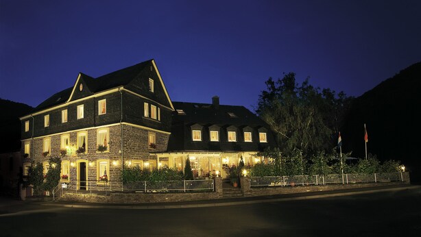 A large, two-story building with multiple windows and a well-lit entrance. - Hotel Gräffs-Mühle (Traben-Trarbach)