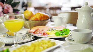 A breakfast setting with plates of food, a glass of orange juice, and a pitcher. - Hotel Gräffs-Mühle (Traben-Trarbach)