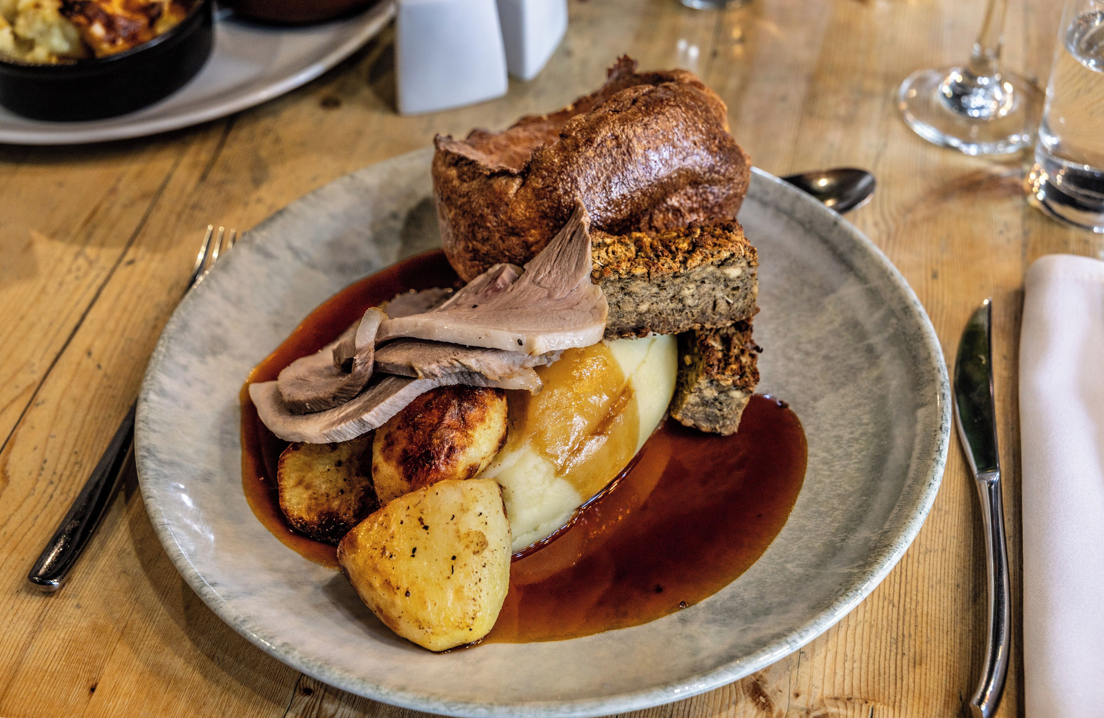 A plate of food with roast beef, mashed potatoes, and gravy.